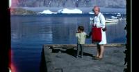 Child throwing his pacifier in the harbor in Uummannaq